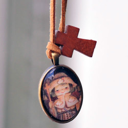 Medalla plateada ovalada  con cristal lupa 2x3 cm. Imagen "Apóstol Santiago". Cinta de ante camel y mini cruz de madera.